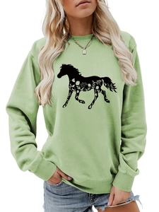 Detailed view of the white floral horse print on a mint green long sleeve sweatshirt