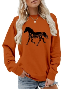Detail of burnt orange crewneck sweatshirt featuring a black horse floral silhouette