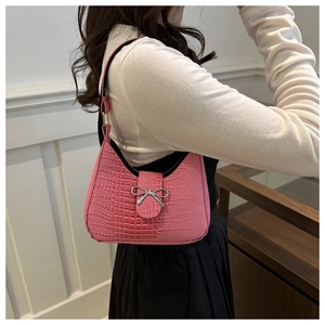 Dettaglio borsa a spalla rosa texture coccodrillo con fiocco in metallo argento