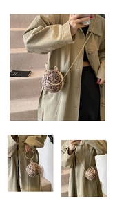 Detail of spherical leopard print evening bag with golden metal ring handle and chain