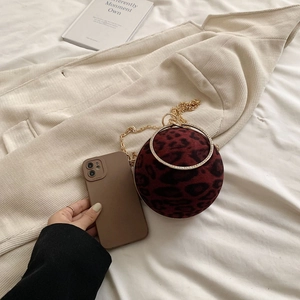 Detailed view of leopard print sphere evening bag with large gold metal ring handle
