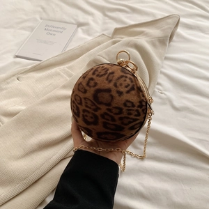 Detail of leopard print ball-shaped evening clutch with gold chain and plush texture