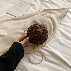 Detail of leopard print round bag featuring gold circular handle and fine metal chain