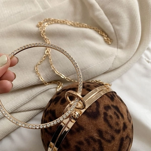Detail of leopard print ball evening bag featuring rhinestone-encrusted golden handle
