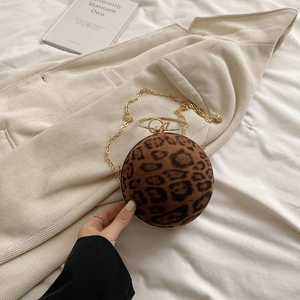 Detailed view of spherical leopard print bag with gold ring handle and detachable chain