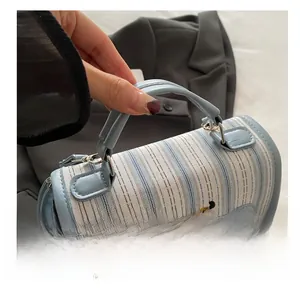 Detail of light blue striped tote bag with cute dachshund embroidery and leather handle