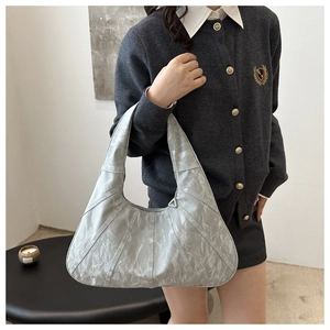 Detailed view of silver hobo bag with pleated metallic finish and radial stitching
