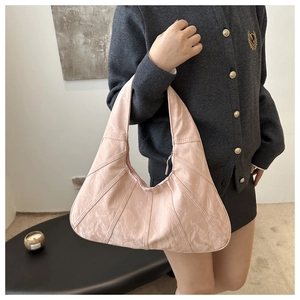 Detail of light pink wrinkled texture hobo bag worn by model in casual lifestyle setting