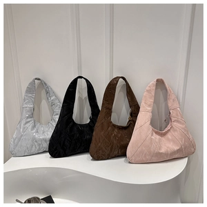 Detailed view of four pleated metallic tote bags in silver, black, brown, and pink finishes