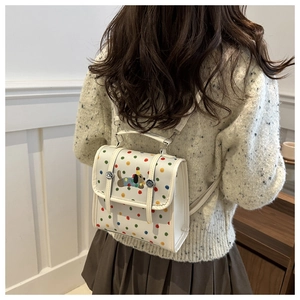 Detailed shot of white polka dot dachshund backpack with silver metal swivel closure