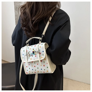 Polka dot mini square bag with cartoon dog embroidery shown on model in cross-body style