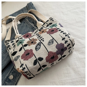Detail of floral tapestry canvas bag with silver magnetic snap and woven texture