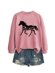 Flat lay of pink horse print sweatshirt with distressed denim shorts and floral pattern