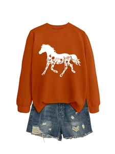 Detailed view of caramel orange sweatshirt featuring white horse silhouette and floral print