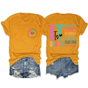 Close-up of mustard yellow cotton T-shirt with motivational text and ripped denim shorts