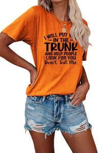Close-up of orange crew neck T-shirt with black text print paired with denim shorts