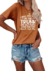 Detail of caramel orange t-shirt with white slogan and distressed denim shorts set