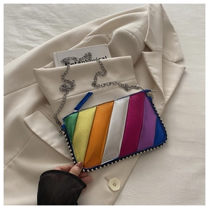 Détail du sac à bandoulière rayé arc-en-ciel avec clous et chaîne en métal argenté
