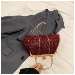 Macro view of a red fringe handbag with golden metal frame and round bead clasps