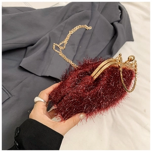 Detailed view of wine red faux fur handbag with golden chain and circular metal handle