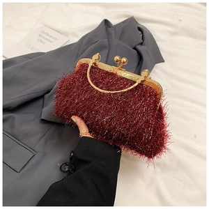 Detail of burgundy fringe evening bag with gold metal frame and ball clasp closure