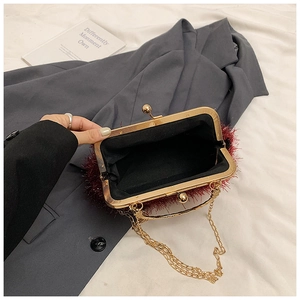 Detail of red tassel evening bag with gold chain strap on a stylish blazer background