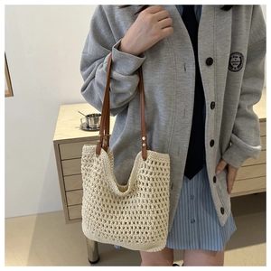Close-up of beige hollow-out woven texture and brown leather straps on a tote bag