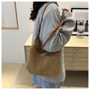 Detail of hollow woven shoulder bag showing khaki mesh texture and brown leather strap