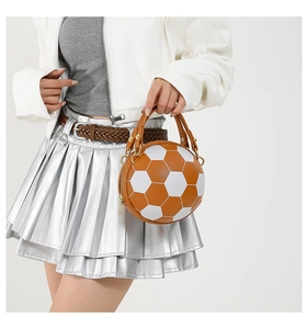 Detail of soccer ball handbag featuring brown and white leather panels and metal zipper
