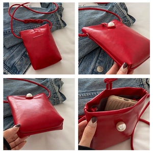 Vue détaillée de ce petit sac bandoulière rouge avec fermoir perle élégant