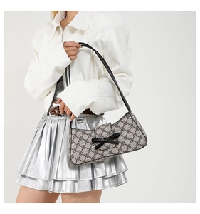 Detail der Monogramm-Schultertasche mit schwarzer Schleife zum Bikerjacken-Look