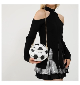 Detail einer Handtasche in Fußballform mit schwarz-weißen Feldern und goldener Kette