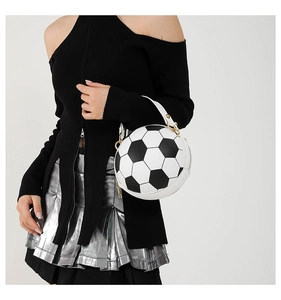 Detailed view of football shaped handbag with white leather handle and gold hardware