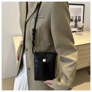 Mini sac à téléphone noir chic avec grande boucle en perle et bandoulière tressée sur mannequin