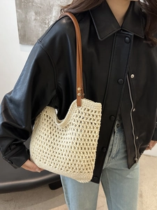 Beige hollow crochet tote bag with brown leather straps shown on model shoulder