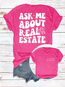 Détail d'un t-shirt rose vif avec texte 'ASK ME ABOUT REAL ESTATE' et motif de maison