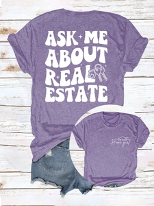 Gros plan d'un t-shirt violet avec imprimé immobilier sur un fond en bois rustique