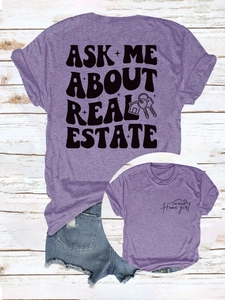 Détail du t-shirt violet avec impression 'Ask Me About Real Estate' et motif de clé