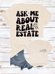 Détail d'un t-shirt en coton crème avec slogan immobilier noir et motifs de clés