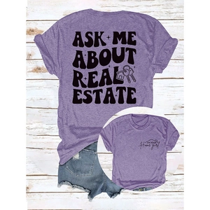 T-shirt violet Ask Me About Real Estate et short en jean bleu sur fond en bois blanc