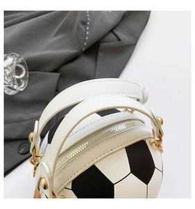 Detail of football-shaped handbag showing textured leather and gold chain hardware