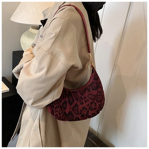 Détail du sac croissant léopard bordeaux avec texture en daim et boucles dorées
