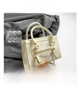 Detail of cream marble pattern handbag with gold zippers and detachable shoulder strap