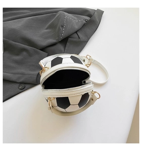 Detail of creative football-shaped crossbody bag with black white panels and gold zipper