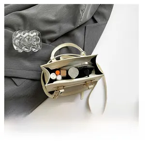 Internal view of cream small crossbody bag showing storage for phone and cosmetics