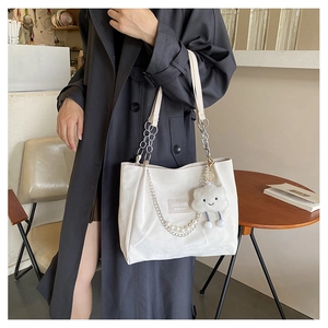 Détail du sac cabas blanc en velours avec chaîne argentée, perles et porte-clé nuage