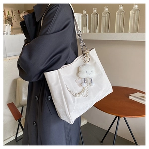 Détail d'un grand sac cabas blanc avec chaîne de perles et charm nuage en peluche