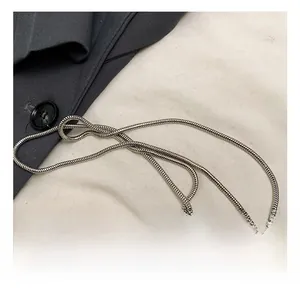 Detailed macro view of a fine silver snake chain strap with metallic luster on grey fabric