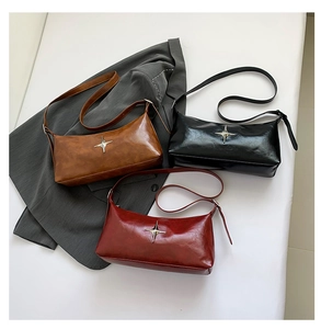 Detailed close-up of retro pillow bags in brown, black, and red with silver star motifs