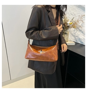 Detail of vintage brown shoulder bag with silver star buckle worn on the shoulder